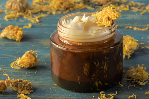 Go Native NZ recipe Calendula Cream homemade pamper in amber pot on blue wood with dried flowers