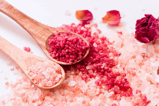 Make Your Own Fresh flower bath salts two bright pink and red colour on wooden spoons