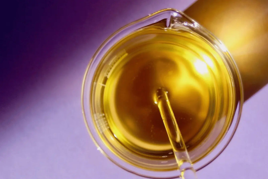 homemade Passionfruit Cleansing Oil Go Native NZ skincare recipe amber colour in glass beaker on purple