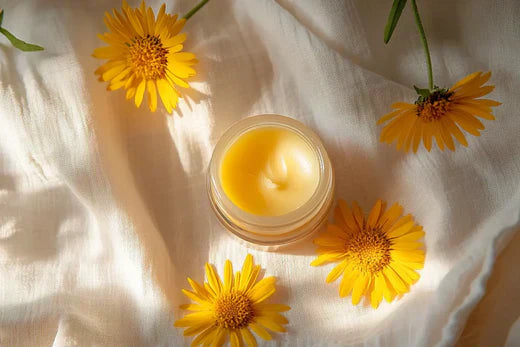 German chamomile essential oil balm, light creamy yellow Go Native NZ recipe in glass pot surrounded by flowers