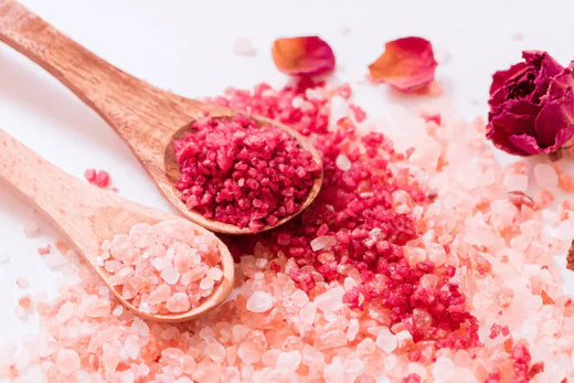 Make Your Own Fresh flower bath salts two bright pink and red colour on wooden spoons