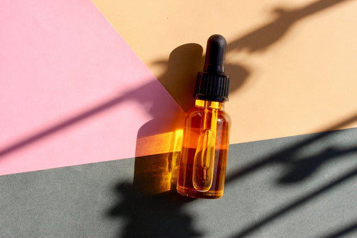 DIY Liquid Gold Skin Replenishing Serum Go Native New Zealand recipe in clear glass bottle on 3 colour card flat-lay styled in sunlight