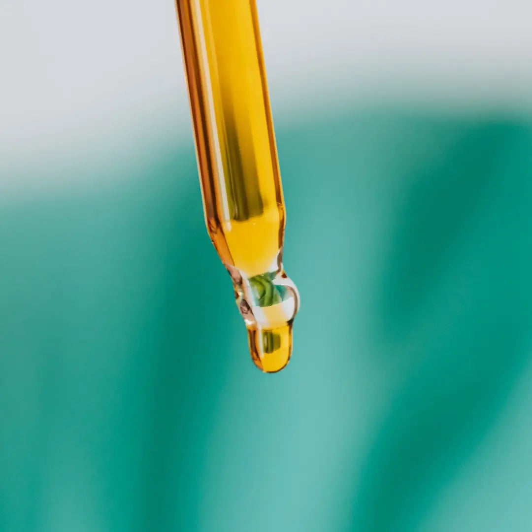 Close-up of a dropper with a yellow to amber bakuchiol liquid on a blurred green background from Go Native NZ