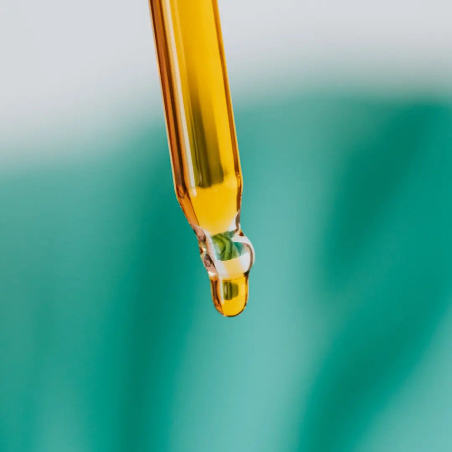 Close-up of a dropper with a yellow to amber bakuchiol liquid on a blurred green background from Go Native NZ