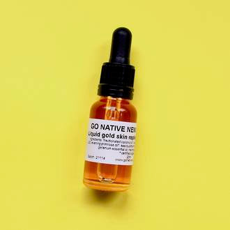 Liquid gold skin replenishing serum in a clear glass dropper bottle with Go Native NZ label, on bright yellow background
