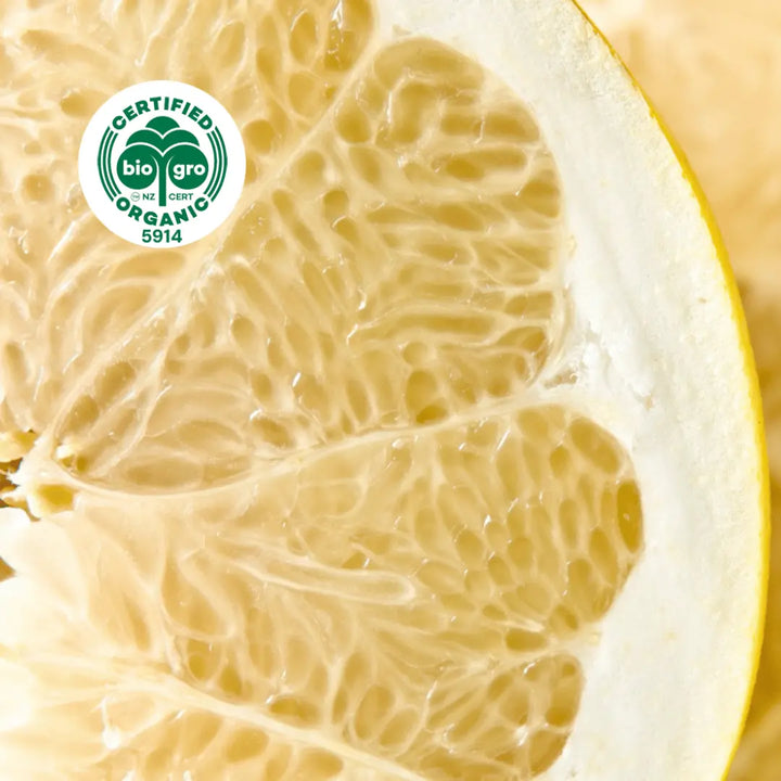 Go Native NZ detail of cut open slice of yellow grapefruit Essential Oil with Bio Gro Icon verifying Certified Organic status